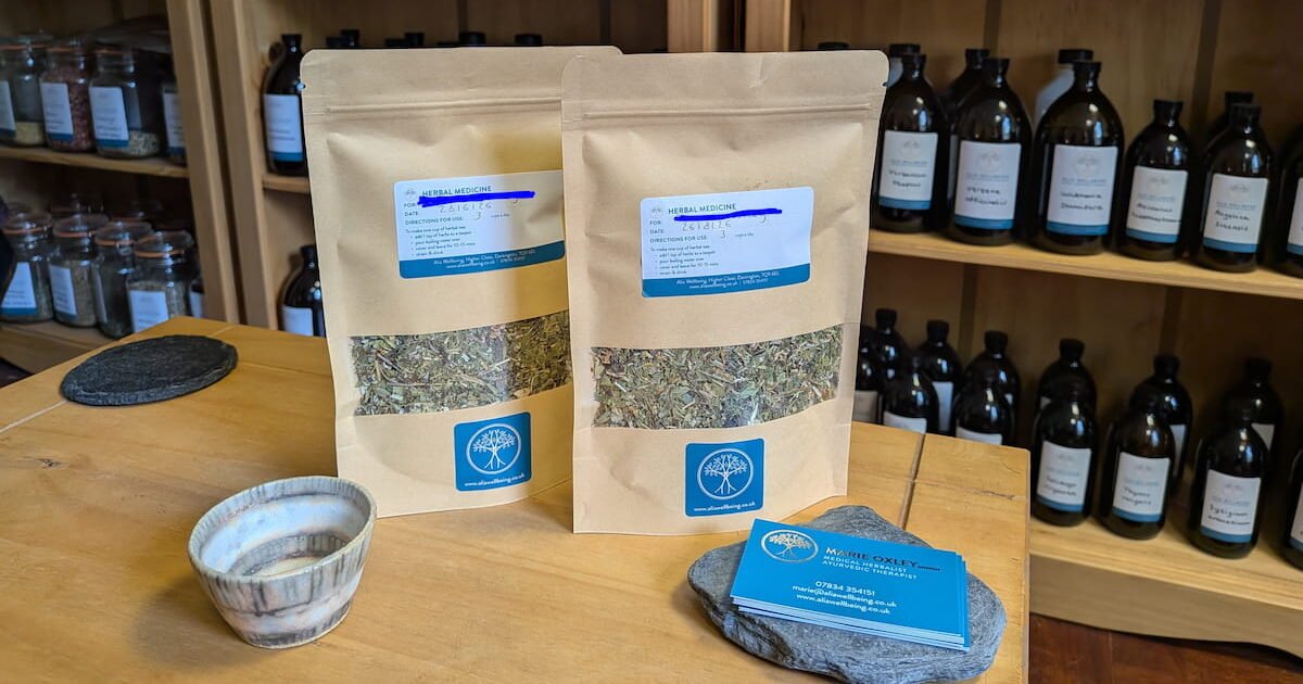 herbal teas two packets of herbal tea on a table with bottles of tincture in the background